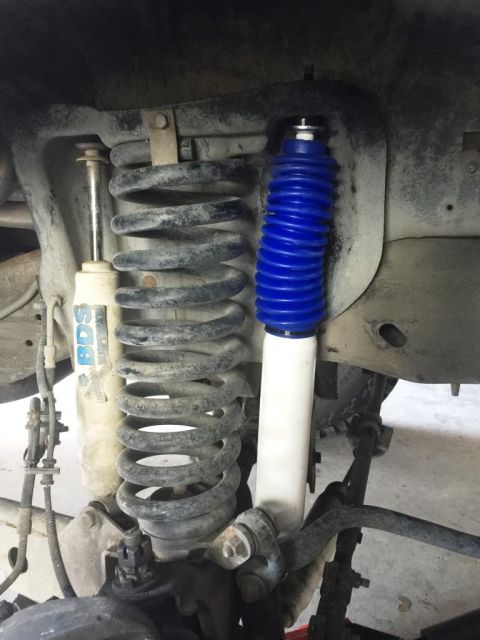 1996 Ford Bronco - Close-up view of vehicle suspension components, including a blue-booted shock and a BDS shock absorber.
