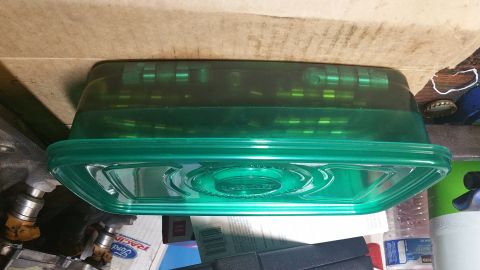 1995 Ford Mustang - A green plastic container filled with small green cylindrical objects is placed on a surface with other items. The container has a lid with…