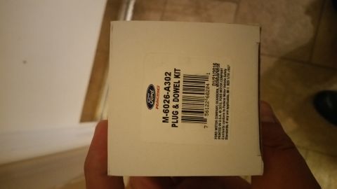 1995 Ford Mustang - A hand holds a white Ford Racing box with a part number M-6026-A302 and the text "PLUG & DOWEL KIT" visible. The box also shows a barcode a…