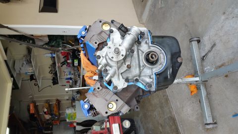 1995 Ford Mustang - A disassembled V8 engine, likely a Ford small block, is mounted on an engine stand. The water pump and front timing cover are attached, wit…