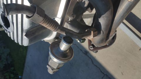 1995 Ford Mustang - A close-up view shows a metal sensor attached to an engine component, with exhaust pipes visible in the background.