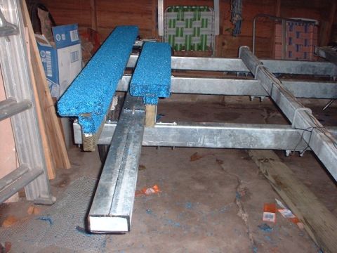 1996 Ford Taurus - Boat trailer frame with blue bunks, likely in a garage or workshop.