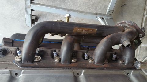 1995 Ford Mustang - A close-up view of a Ford engine's exhaust manifold and spark plugs. The exhaust manifold features a "Ford Motorsport" plaque and is bolted…