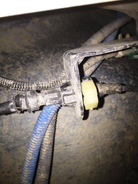 1996 Ford Bronco - Close-up view of the electrical wiring and connectors located beneath the vehicle's center console.
