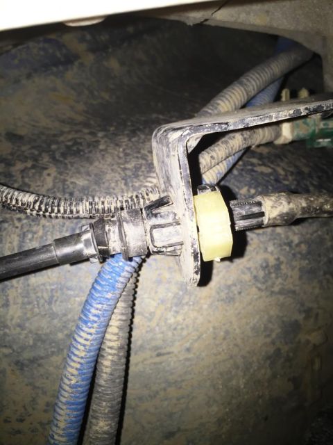 1996 Ford Bronco - Detail of automotive fuel lines and wiring harness secured by a bracket, showing corrugated tubing and connectors.
