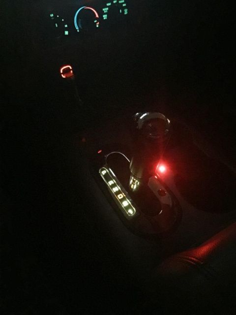 1996 Ford Bronco - The illuminated gear selector and dashboard lights are visible in the dark interior of the vehicle.
