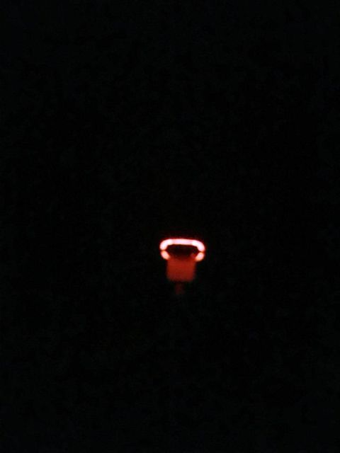 1996 Ford Bronco - A single red indicator light glows in the dark interior of a vehicle, with a website URL visible.