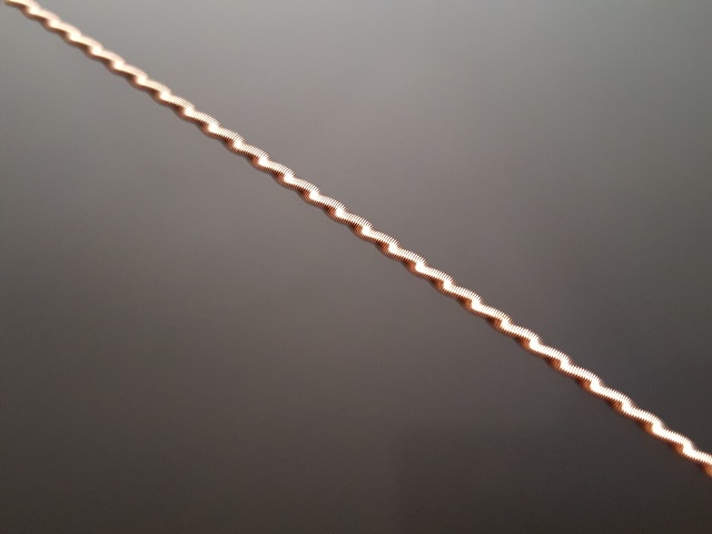 zig-zag metal trim piece with SUPERMOTORS.NET logo at bottom right