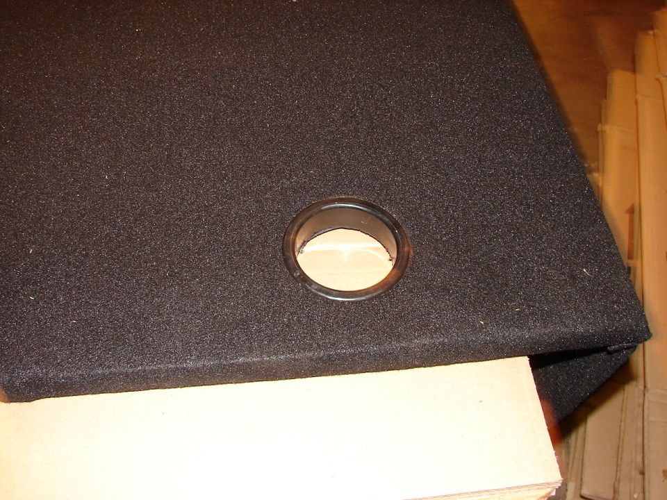 Black fabric-covered box with a circular opening and a wooden interior
