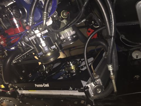1982 Ford Bronco - A close-up, overhead view of a modified engine bay, featuring a Perma-Cool transmission cooler mounted in front of the radiator. Visible co…