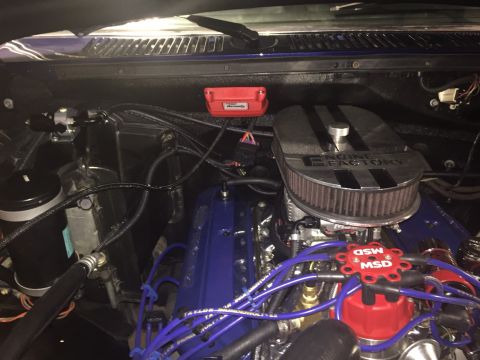 1982 Ford Bronco - A close-up view of a modified engine bay, featuring a blue engine with an "Engine Factory" air cleaner and a red MSD ignition distributor.