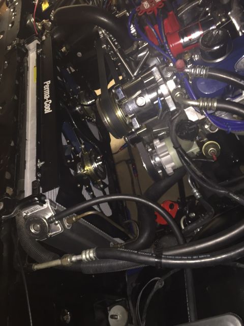 1982 Ford Bronco - A close-up, high-angle view of a highly modified engine bay, featuring a chrome air conditioning compressor, red MSD ignition components, a…