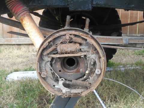 1972 Ford Bronco - The image shows a close-up view of a rusty drum brake assembly on the rear axle of what appears to be a vintage vehicle, possibly a 1972 Fo…