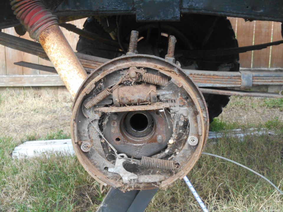 Close-up of a rusty drum brake assembly on a vintage vehicle.