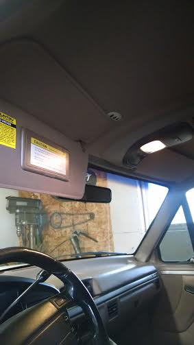 1994 Ford Bronco - Interior view of a 1994 Ford Bronco, showing the driver's side dashboard, steering wheel, and sun visor with a vanity mirror. The vehicle a…