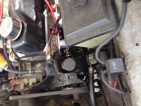 1979 Ford Bronco - Close-up view of an engine bay, highlighting an oil filter and various hoses and components.