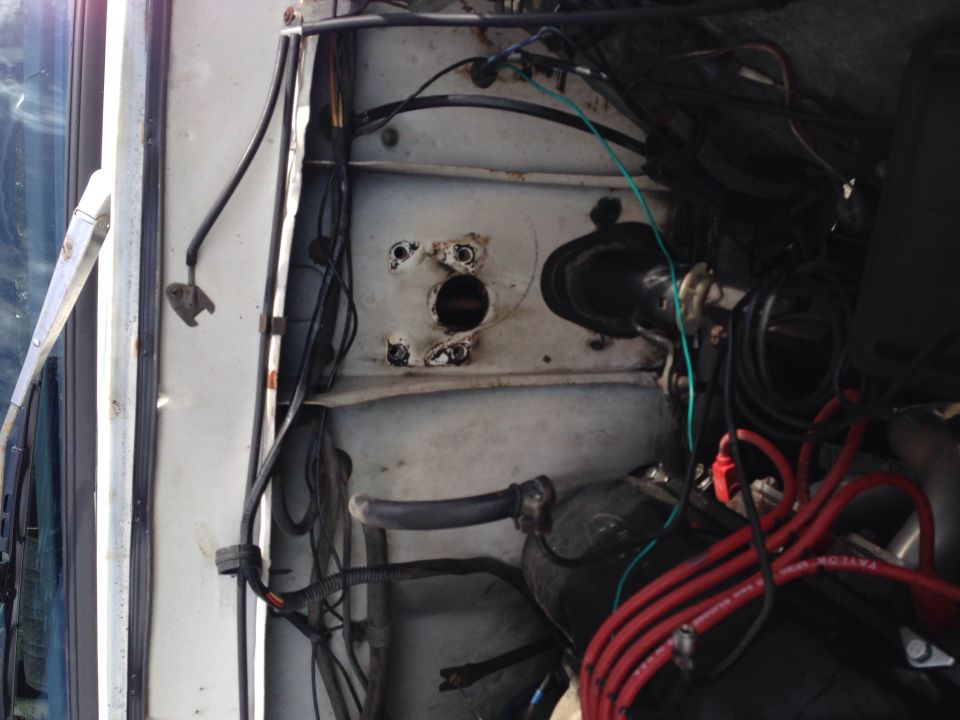 Close-up of a vehicle's engine bay, showing wiring harnesses and some engine components. A Supermotors.net logo is visible at the bottom right