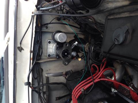 1979 Ford Bronco - Engine bay components including a brake master cylinder and red spark plug wires are visible in this white vehicle.