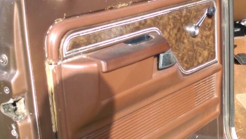 1978 Ford Bronco - Close-up view of the interior door panel, showing the window crank and textured armrest.