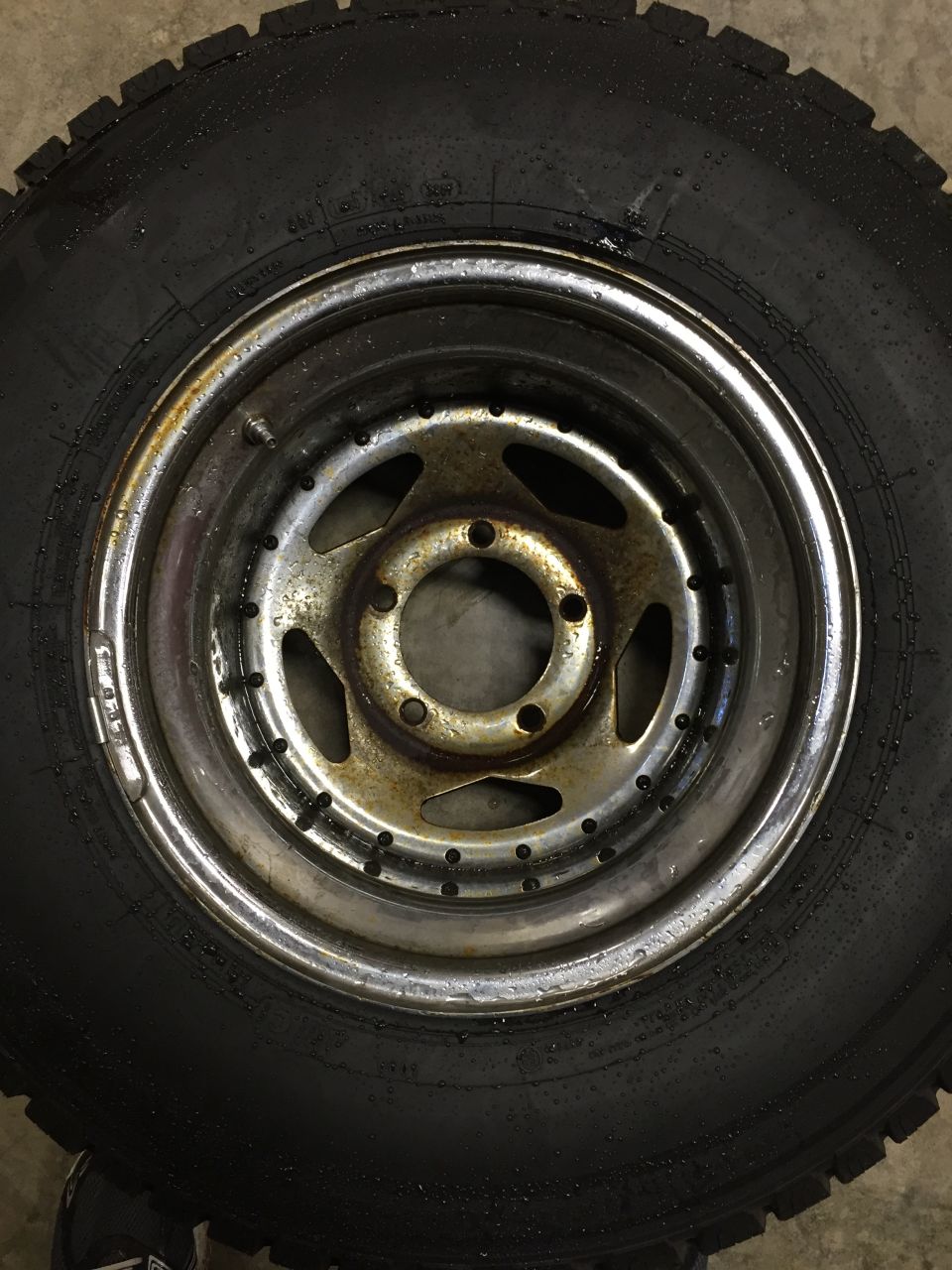 Close-up of a tire and a chrome-plated steel wheel with five pairs of lug nut holes