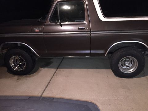 1978 Ford Bronco - The side profile of a classic Ford Bronco shows its two-tone paint scheme and chrome trim.
