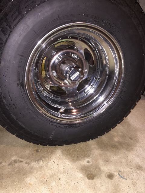 1978 Ford Bronco - A close-up view of a vehicle's wheel and tire, a chrome rim and a 'WARN' branded center cap.