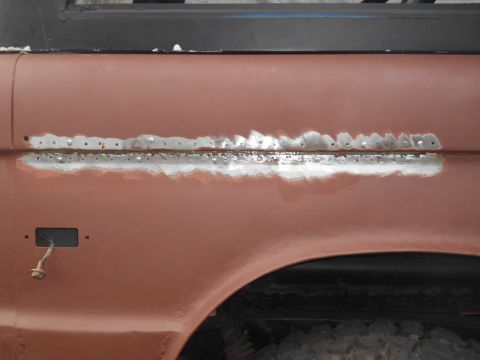 1972 Ford Bronco - Side panel of a 1972 Ford Bronco undergoing rust repair and priming.