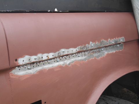 1972 Ford Bronco - A metal patch is being riveted onto the fender of a 1972 Ford Bronco during restoration.