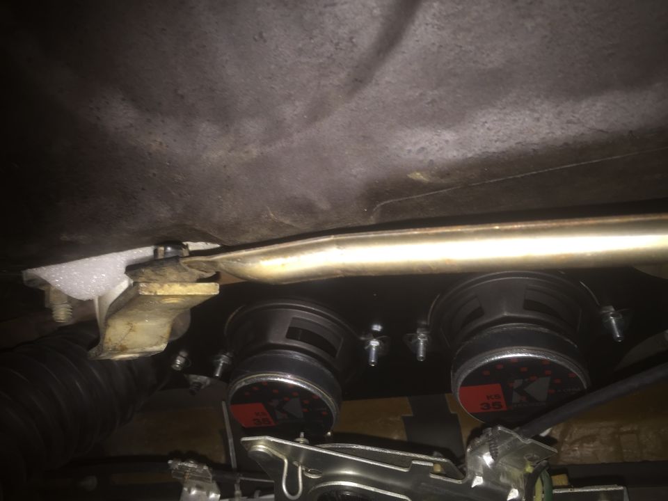 Two Kicker car speakers mounted under a car's dashboard