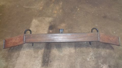 1985 Ford Bronco - A custom fabricated steel bumper with D-ring shackle mounts and a receiver hitch is shown lying on a concrete floor. The bumper has angled…