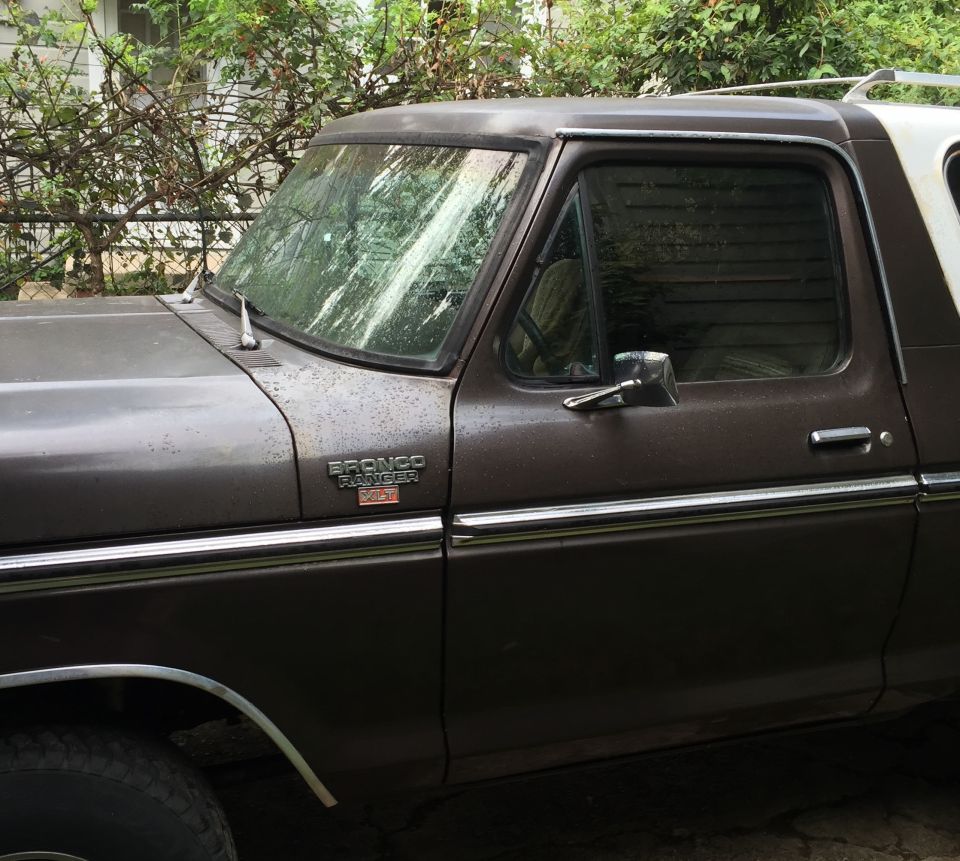 Side view of a brown 1978 Ford Bronco XLT with chrome trim and badges.