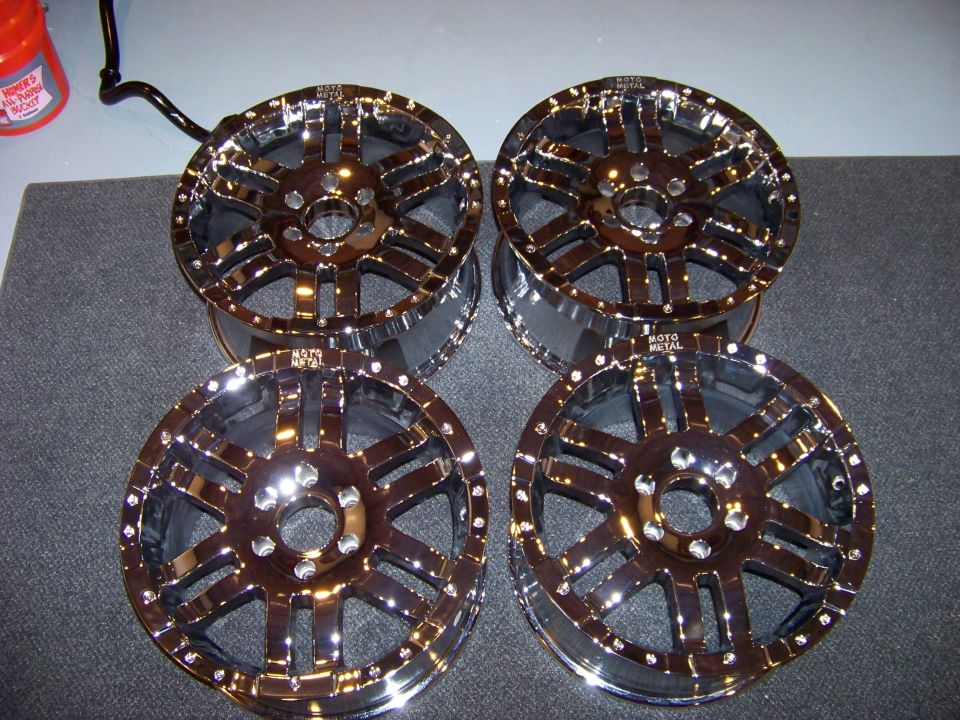 Four chrome Moto Metal wheels with a multi-spoke design.