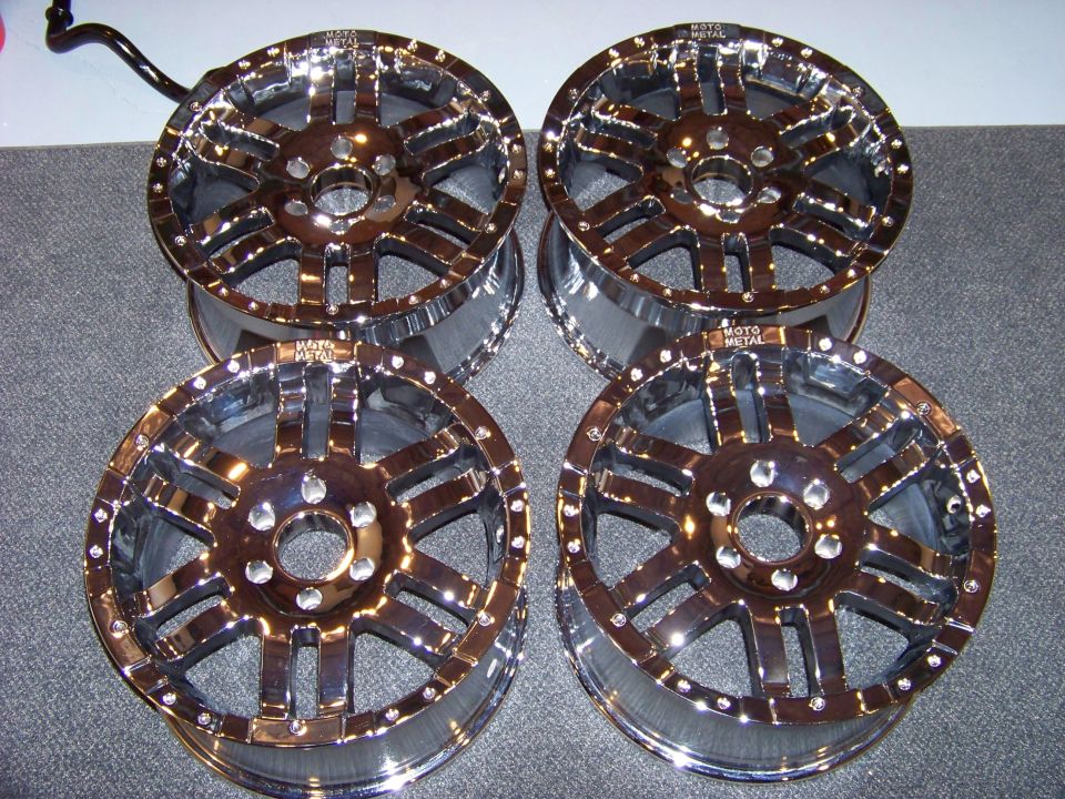 Four chrome Moto Metal wheels with multi-spoke design and bolts around the rim.