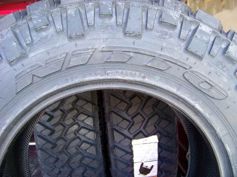 2005 Ford F-150 - A close-up view of two off-road tires, showing the tread pattern and sidewall markings. The tires appear to be mounted on a vehicle, as ind…