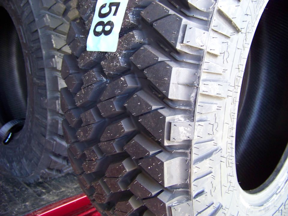 Close-up of two off-road tires, one with a tag showing "58".