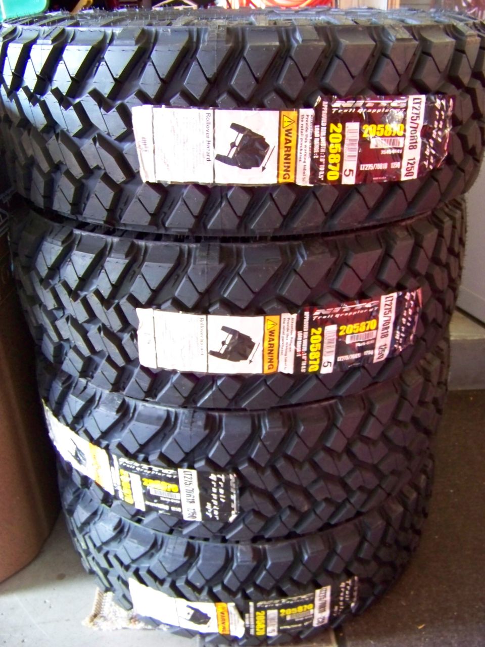 Stack of four new Nitto Trail Grappler LT275/70R18 tires.