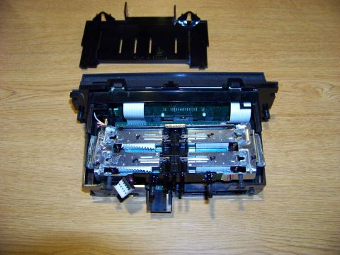 1999 Mercury Grand Marquis - A disassembled electronic component, possibly from a printer or other device, is shown on a wooden surface. The component features circuit…