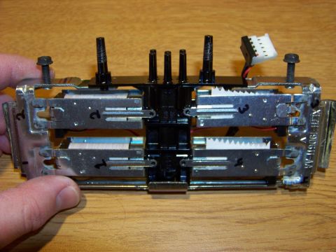 1999 Mercury Grand Marquis - A close-up view shows a mechanical assembly with multiple solenoids, wiring, and a white electrical connector. The assembly is mounted on a…