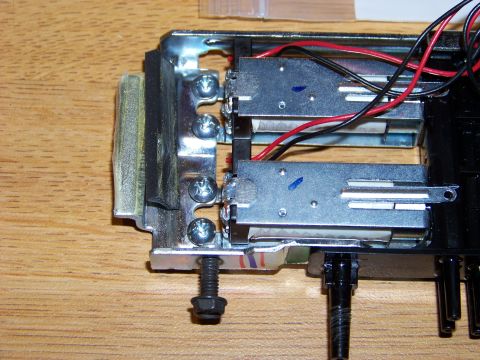 1999 Mercury Grand Marquis - A close-up view of electronic components and wiring attached to a metal bracket, resting on a wooden surface.