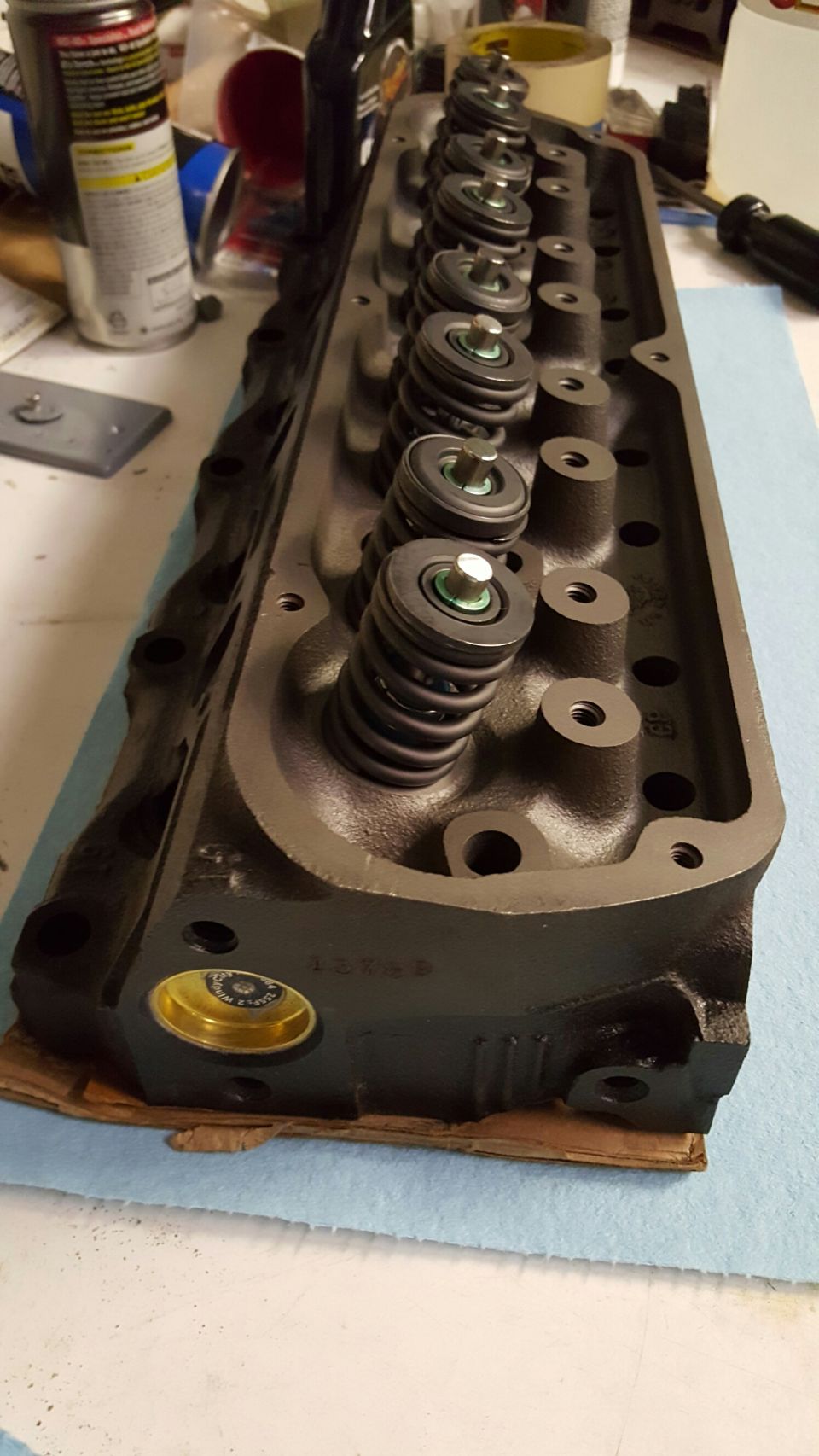 Dark gray V8 engine cylinder head with valve springs and retainers.