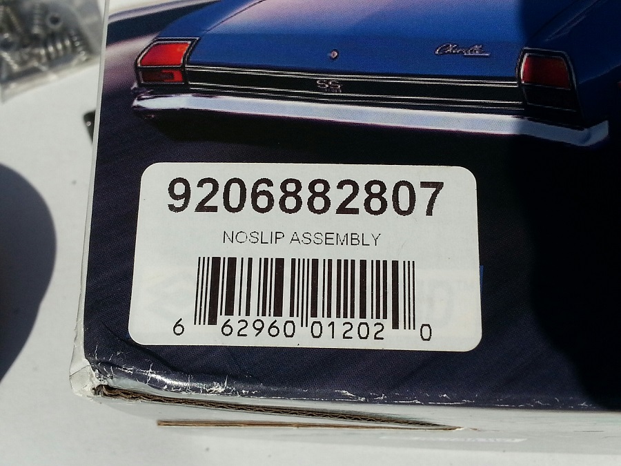 Close-up of a label with barcode and text '9206882807 NOSLIP ASSEMBLY' on a blue car.