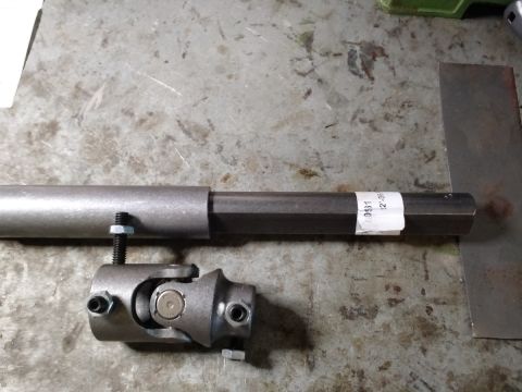 1992 Ford Bronco - A close-up view shows a metal steering shaft with a universal joint attached to its end. A white label with black text is affixed to the sh…
