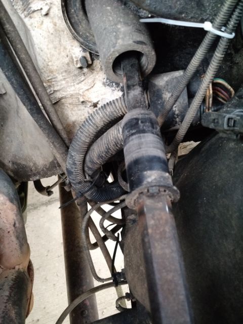 1992 Ford Bronco - A close-up view shows a section of a vehicle's steering column and associated wiring harnesses, secured with zip ties.