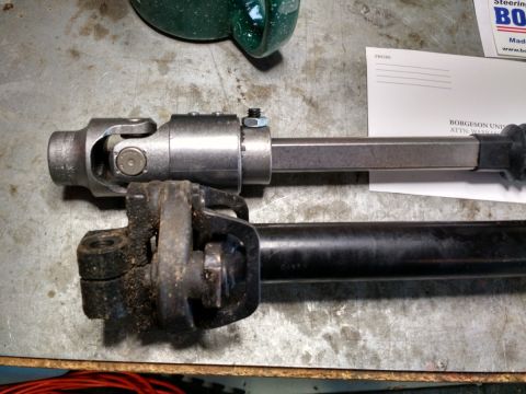 1992 Ford Bronco - Two steering shaft assemblies are laid out for comparison on a metal surface.