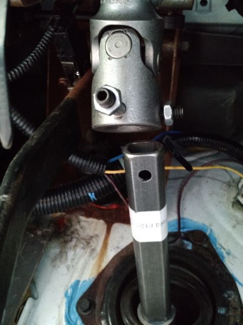 1992 Ford Bronco - Close-up of a steering shaft universal joint and a hex shaft with a white label.