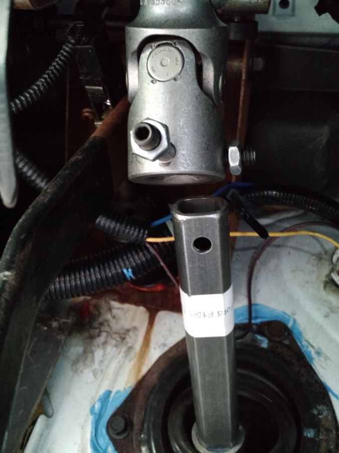 Steering shaft universal joint connected to a hex shaft with a white label