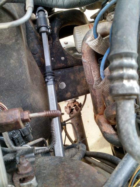 1992 Ford Bronco - Close-up of steering shaft installation in a vehicle's engine bay.