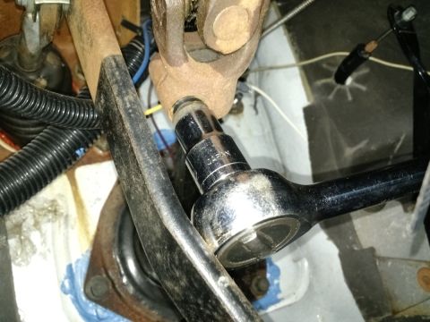 1992 Ford Bronco - Mechanic uses a socket wrench to work on the steering shaft universal joint during an installation.