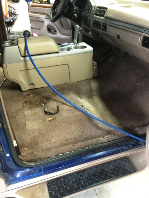 1996 Ford Bronco - Interior view of a 1996 Ford Bronco with the center console removed, showing the carpet area.