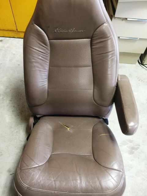 1996 Ford Bronco - This is a brown leather car seat with "Eddie Bauer" branding and damage on the lower cushion.